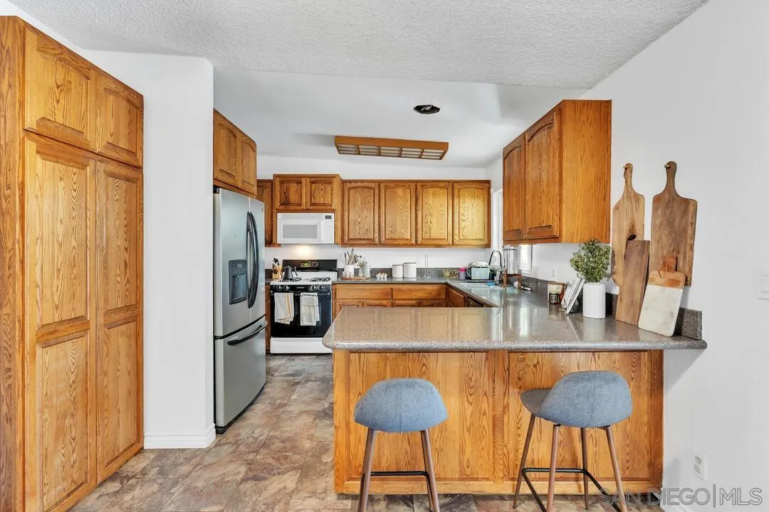 1347 Rex Lane El Cajon, CA 92021 - Photo 11 of 57 a kitchen with granite countertop a refrigerator and a sink
