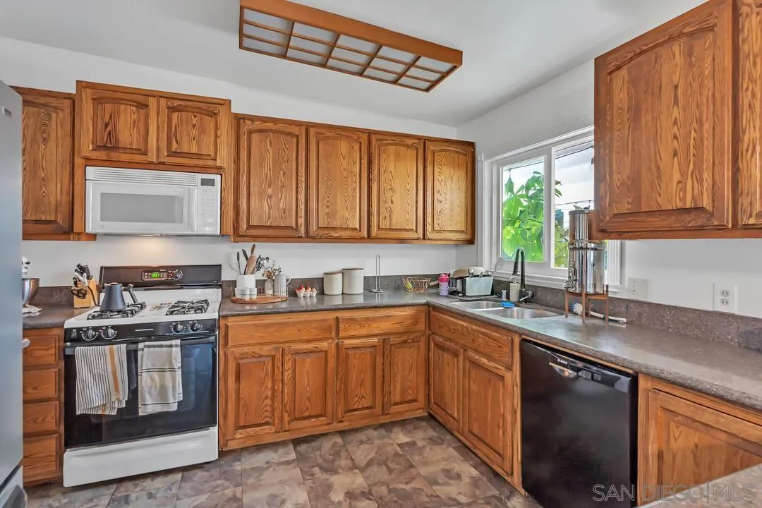 1347 Rex Lane El Cajon, CA 92021 - Photo 13 of 57 a kitchen with a sink stove top oven and cabinets
