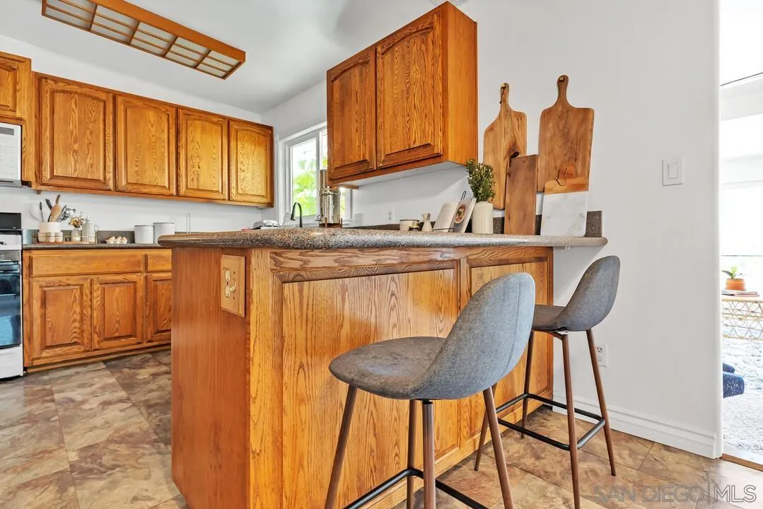 1347 Rex Lane El Cajon, CA 92021 - Photo 16 of 57 a kitchen with stainless steel appliances granite countertop a table chairs and a refrigerator