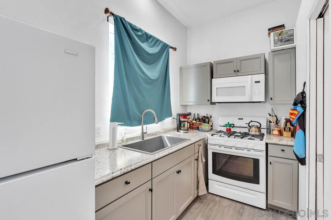 1347 Rex Lane El Cajon, CA 92021 - Photo 41 of 57 a utility room with cabinets stainless steel appliances and a wooden floor