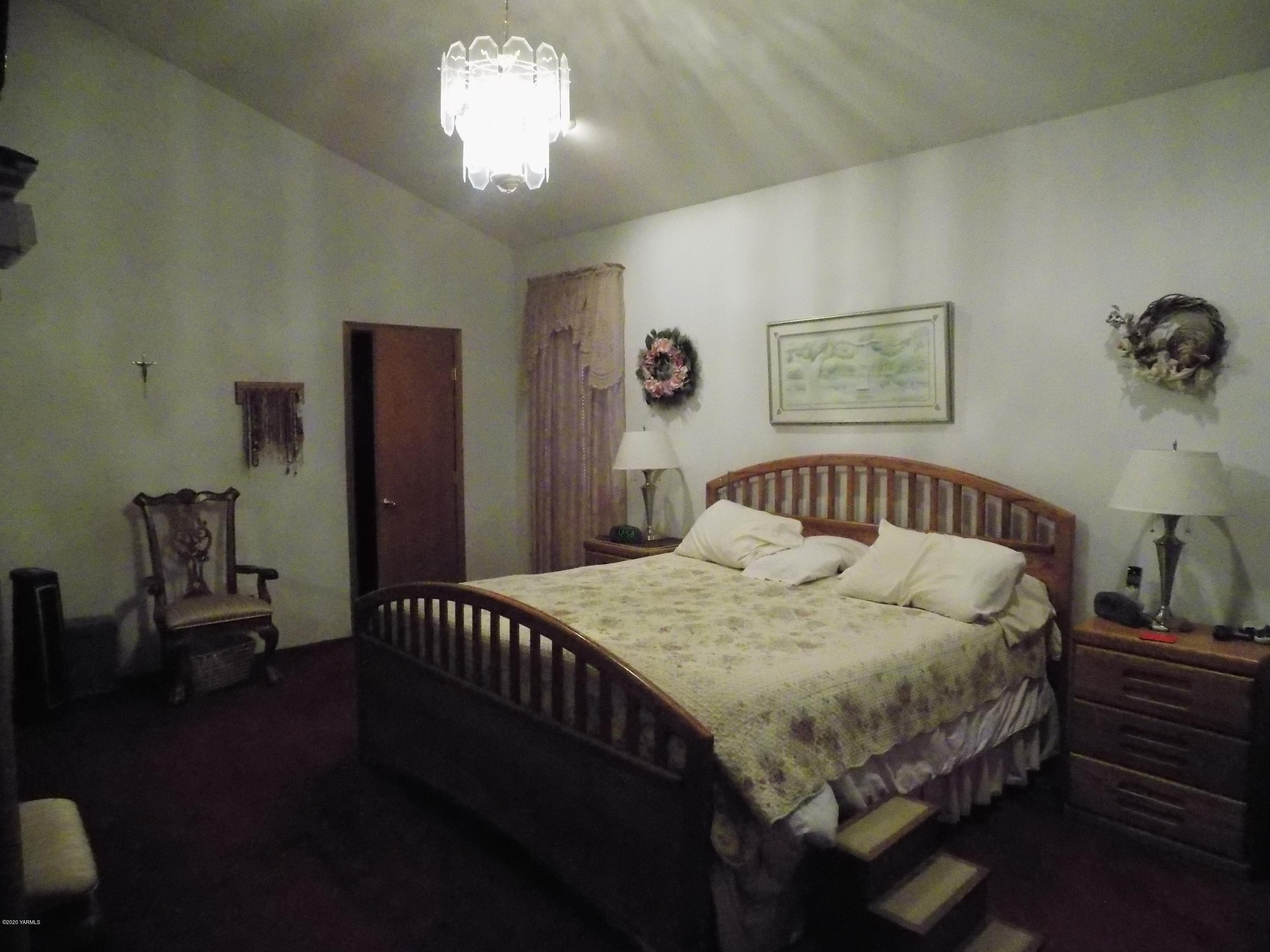 760 Sheep Co Road Selah, WA 98942 - Photo 14 of 37 a bedroom with a bed and a table in it