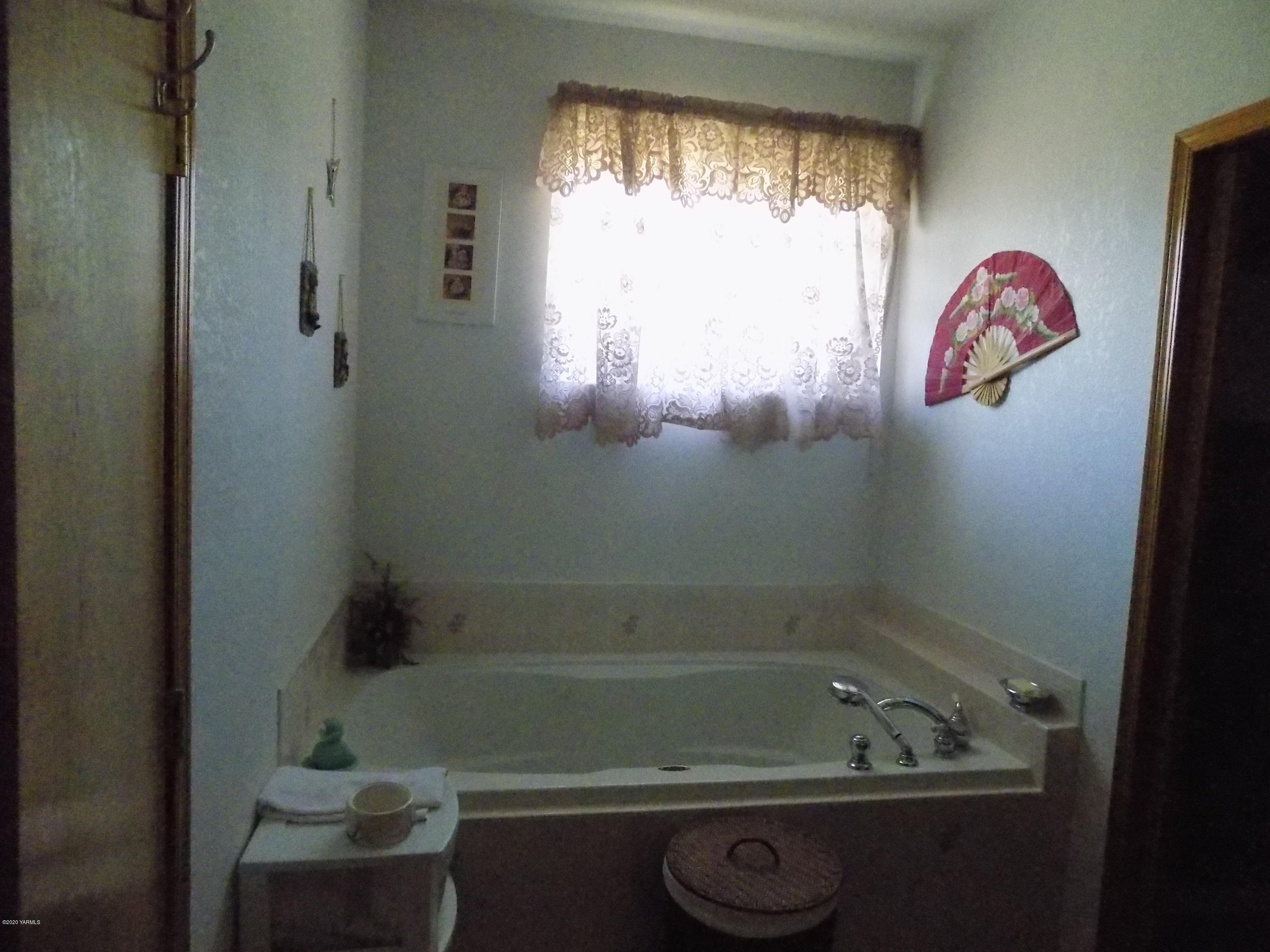 760 Sheep Co Road Selah, WA 98942 - Photo 8 of 37 a bathroom with a bath tub and a window