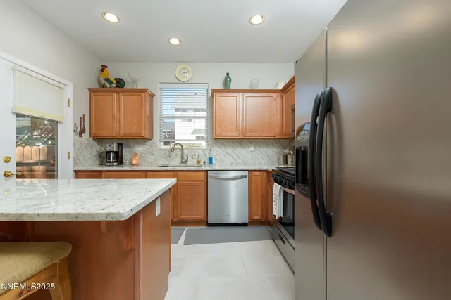 a kitchen with stainless steel appliances granite countertop a sink refrigerator and microwave
