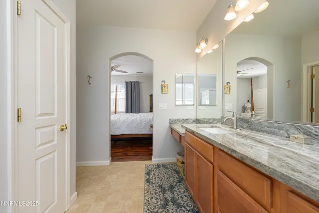 a spacious bathroom with a granite countertop sink and a mirror