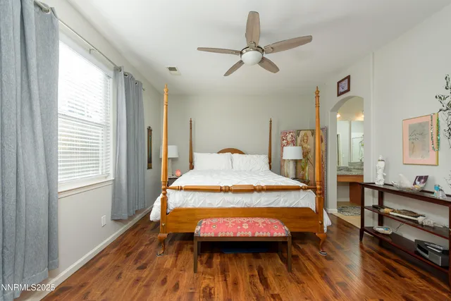 a bedroom with a bed and wooden floor