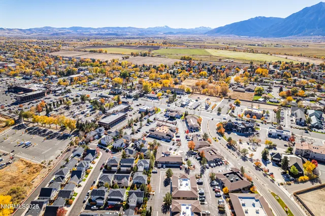 an aerial view of residential houses with outdoor space and trees