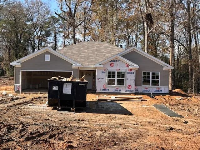 a front view of a house with a yard covered with snow