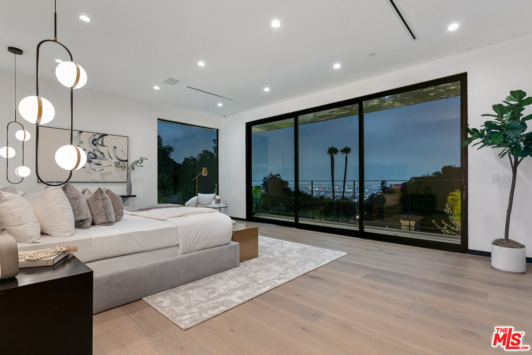 1461 Rising Glen Road Los Angeles, CA 90069 - Photo 15 of 22 a bedroom with a bed and a flat screen tv