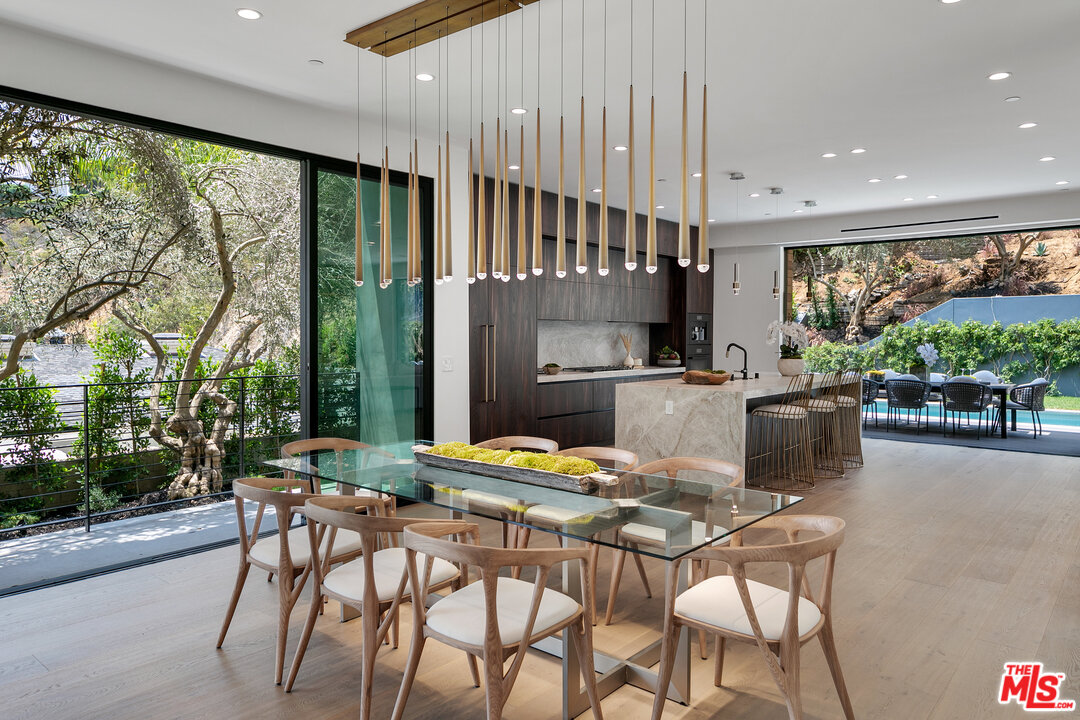 1461 Rising Glen Road Los Angeles, CA 90069 - Photo 8 of 22 a dining room with furniture and a floor to ceiling window