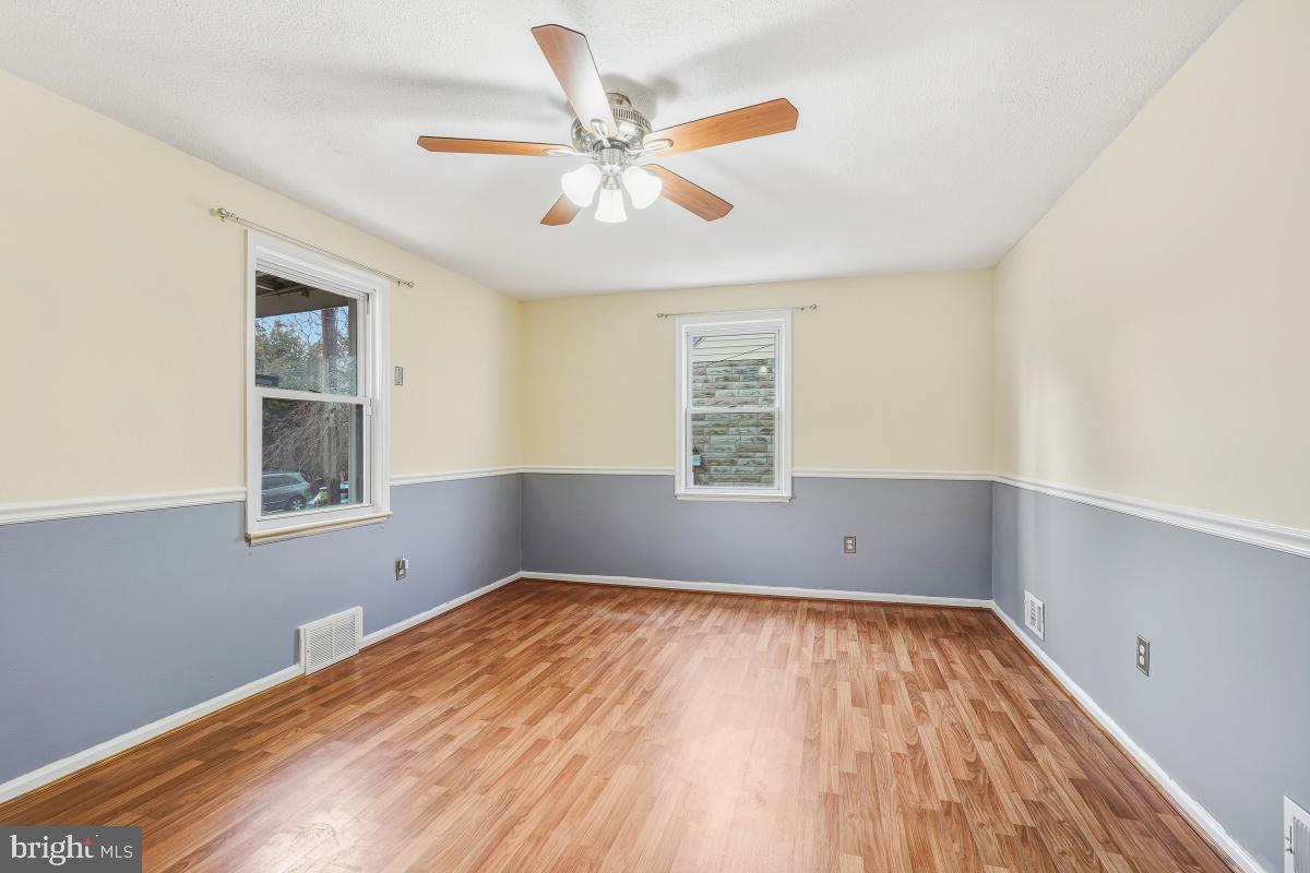 4810 Odell Road Beltsville, MD 20705 - Photo 6 of 30 an empty room with wooden floor chandelier fan and windows