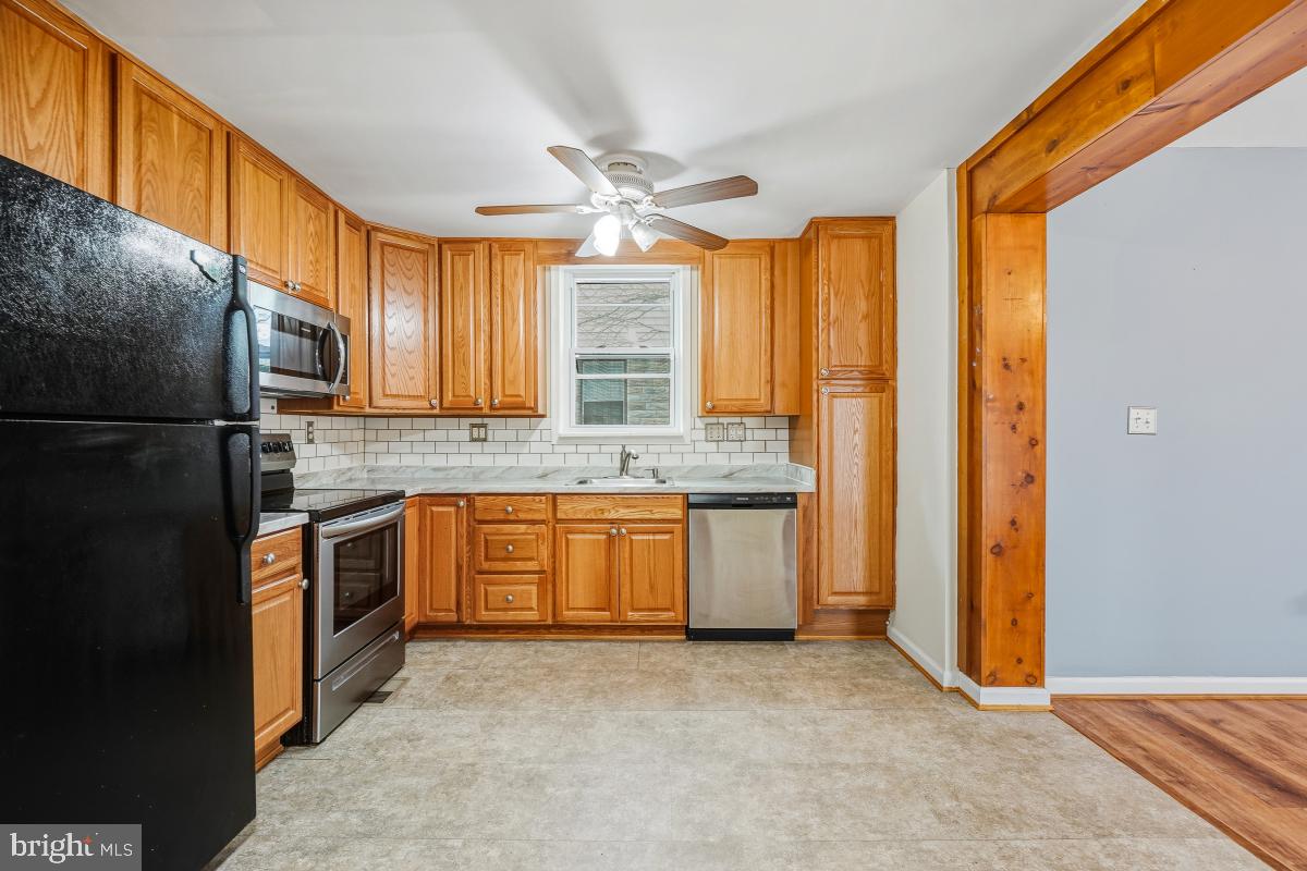 4810 Odell Road Beltsville, MD 20705 - Photo 9 of 30 a kitchen with stainless steel appliances granite countertop a refrigerator a sink dishwasher with a dining table and chairs