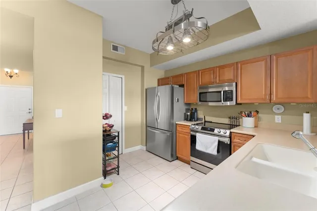 a kitchen with stainless steel appliances granite countertop a refrigerator a stove top oven a sink and dishwasher