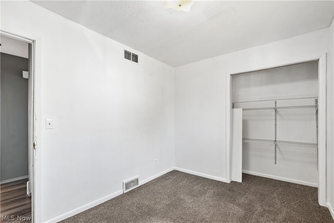 1286 Deforest Road Southeast Warren, OH 44484 - Photo 11 of 27 Carpeted room featuring a built-in closet with shelving, white walls, and white trim