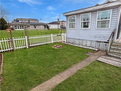 a view of a house with a yard and a wooden deck