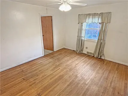 an empty room with wooden floor and door