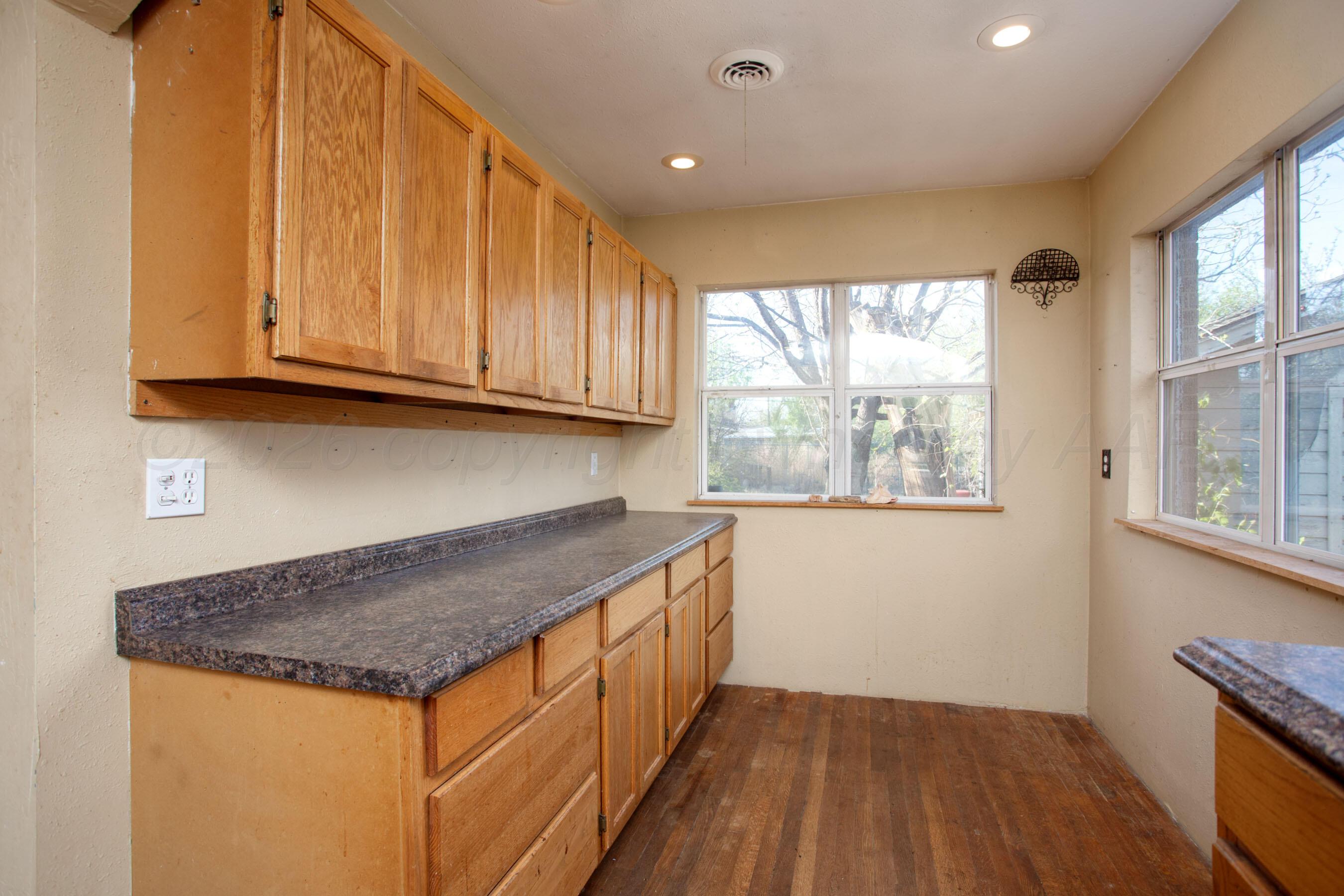4223 Southwest 11th Avenue Amarillo, TX 79106 - Photo 13 of 26 a kitchen with a sink a window and cabinets