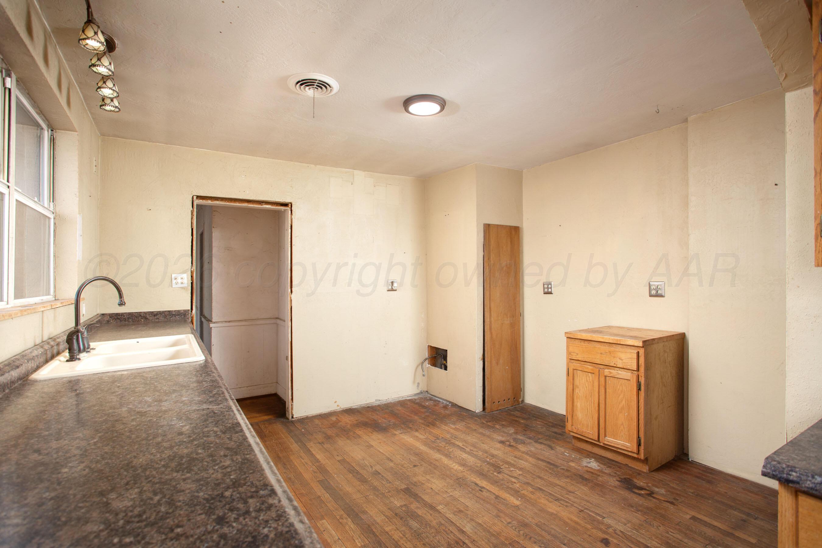 4223 Southwest 11th Avenue Amarillo, TX 79106 - Photo 14 of 26 a view of a kitchen with a sink and dishwasher with wooden floor