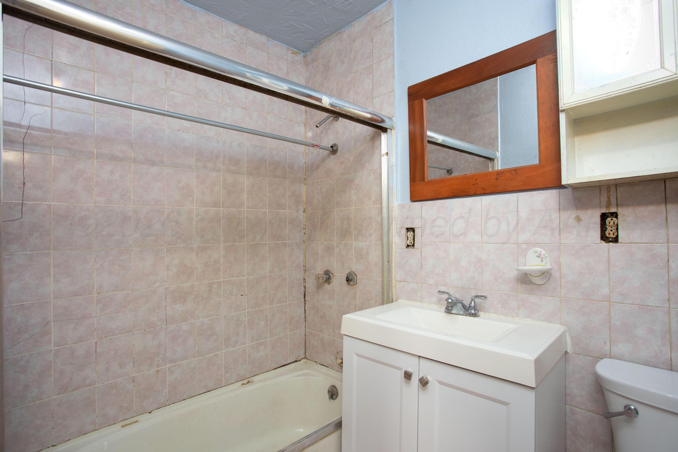 4223 Southwest 11th Avenue Amarillo, TX 79106 - Photo 19 of 26 a bathroom with a sink a toilet and shower