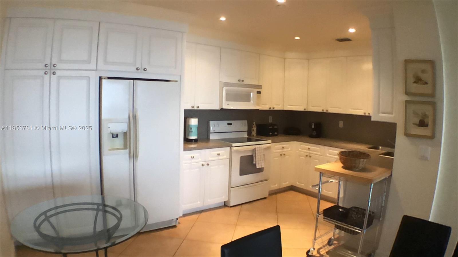 151 Crandon Boulevard, Unit 833 Key Biscayne, FL 33149 - Photo 2 of 12 a kitchen with a refrigerator sink and cabinets