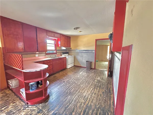 a kitchen with kitchen island granite countertop a stove refrigerator and sink