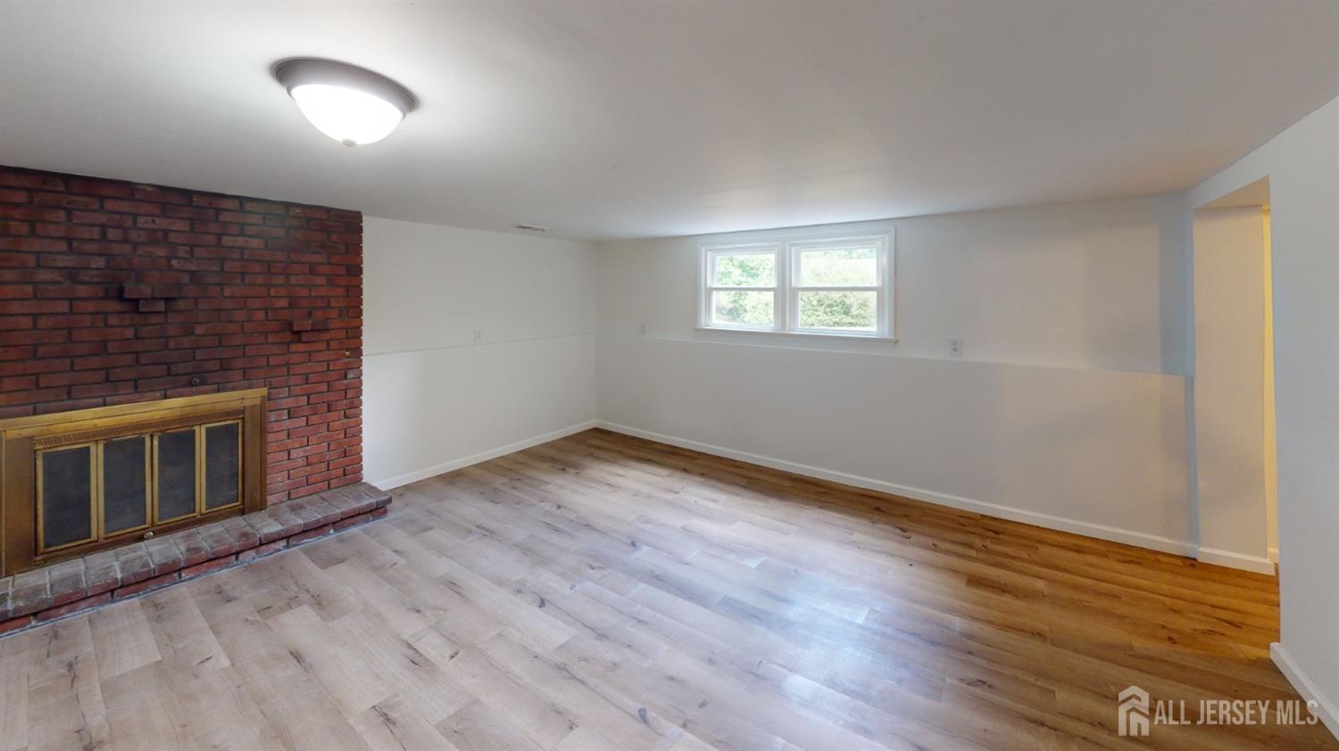3 Donald Road East Brunswick, NJ 08816 - Photo 49 of 62 a view of an empty room with wooden floor and a fireplace