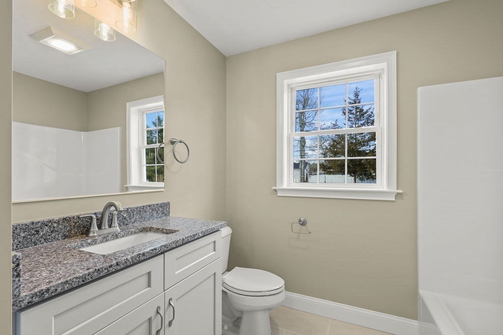 81 Maple Springs Road Wareham, MA 02571 - Photo 9 of 17 a bathroom with a granite countertop sink a toilet and a window