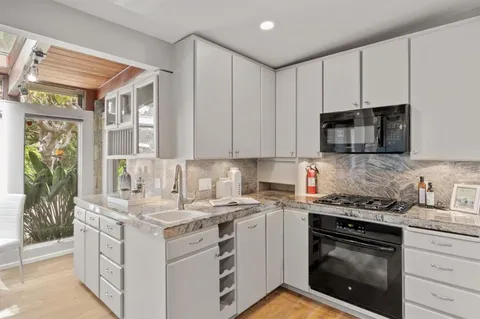 a kitchen with stainless steel appliances granite countertop a stove and a microwave