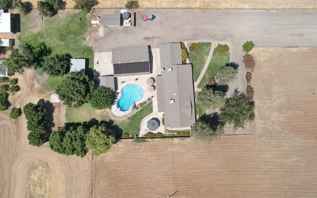 an aerial view of a house with a yard and potted plants