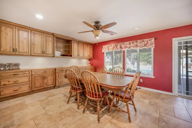 a kitchen with stainless steel appliances granite countertop table chairs stove and cabinets