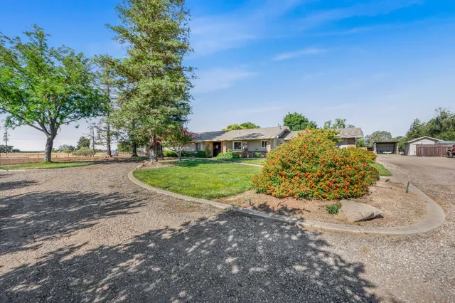 front view of a house with a yard and potted plants