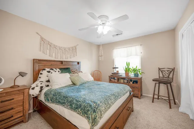a view of a room with a ceiling fan and window