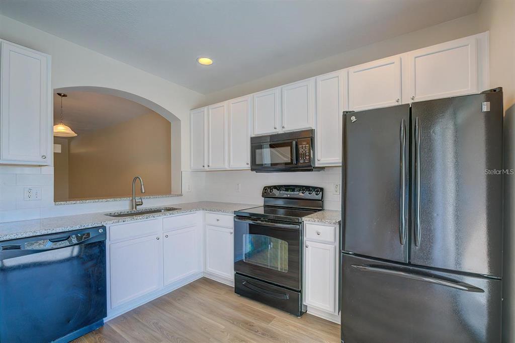 15706 Stable Run Drive Spring Hill, FL 34610 - Photo 15 of 40 a kitchen with stainless steel appliances a refrigerator stove and sink