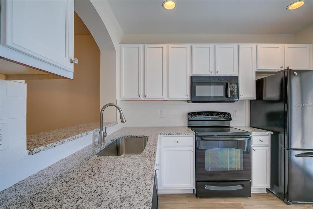 15706 Stable Run Drive Spring Hill, FL 34610 - Photo 16 of 40 a kitchen with appliances a sink and cabinets
