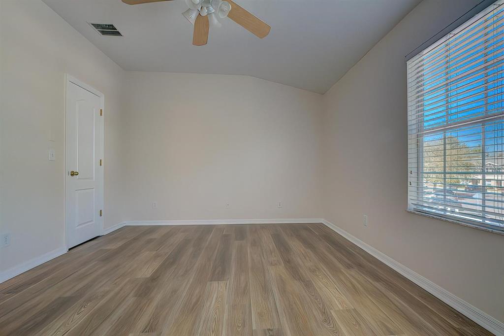 15706 Stable Run Drive Spring Hill, FL 34610 - Photo 22 of 40 an empty room with wooden floor and windows