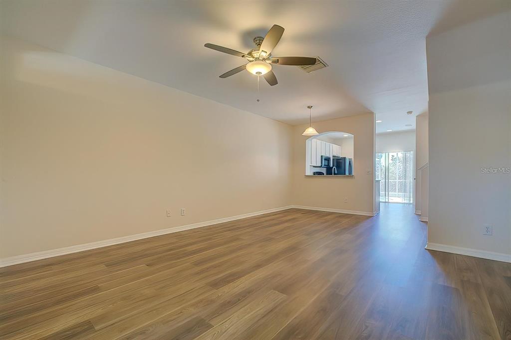 15706 Stable Run Drive Spring Hill, FL 34610 - Photo 5 of 40 a view of an empty room with wooden floor and a ceiling fan