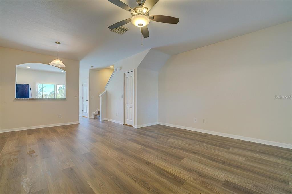 15706 Stable Run Drive Spring Hill, FL 34610 - Photo 8 of 40 an empty room with wooden floor fan and windows