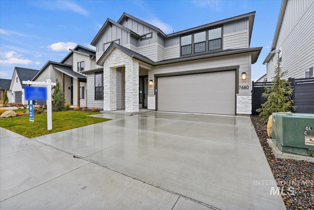 7566 West Old School Street, Unit ROUGE Meridian, ID 83646 - Photo 2 of 28 View of front of house featuring stone siding, concrete driveway, board and batten siding, and a garage
