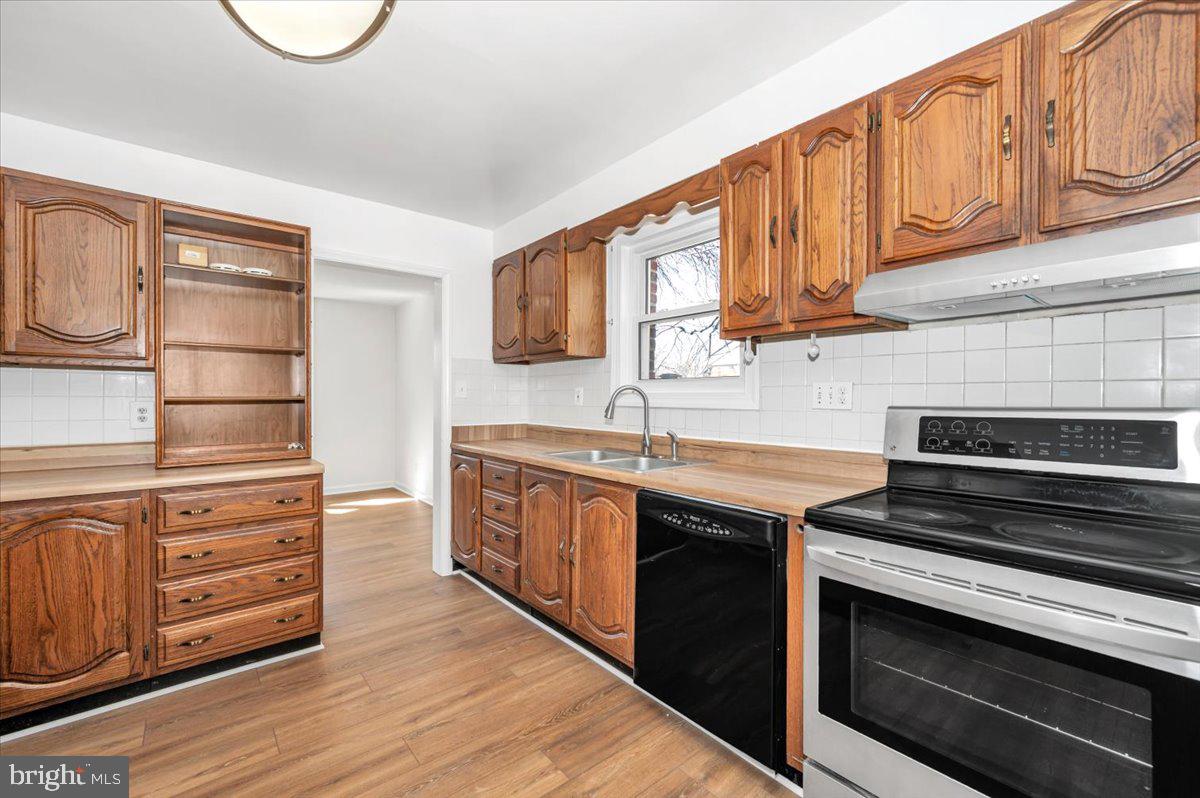 11852 Huggins Drive Silver Spring, MD 20902 - Photo 12 of 63 a kitchen with stainless steel appliances a stove microwave and cabinets