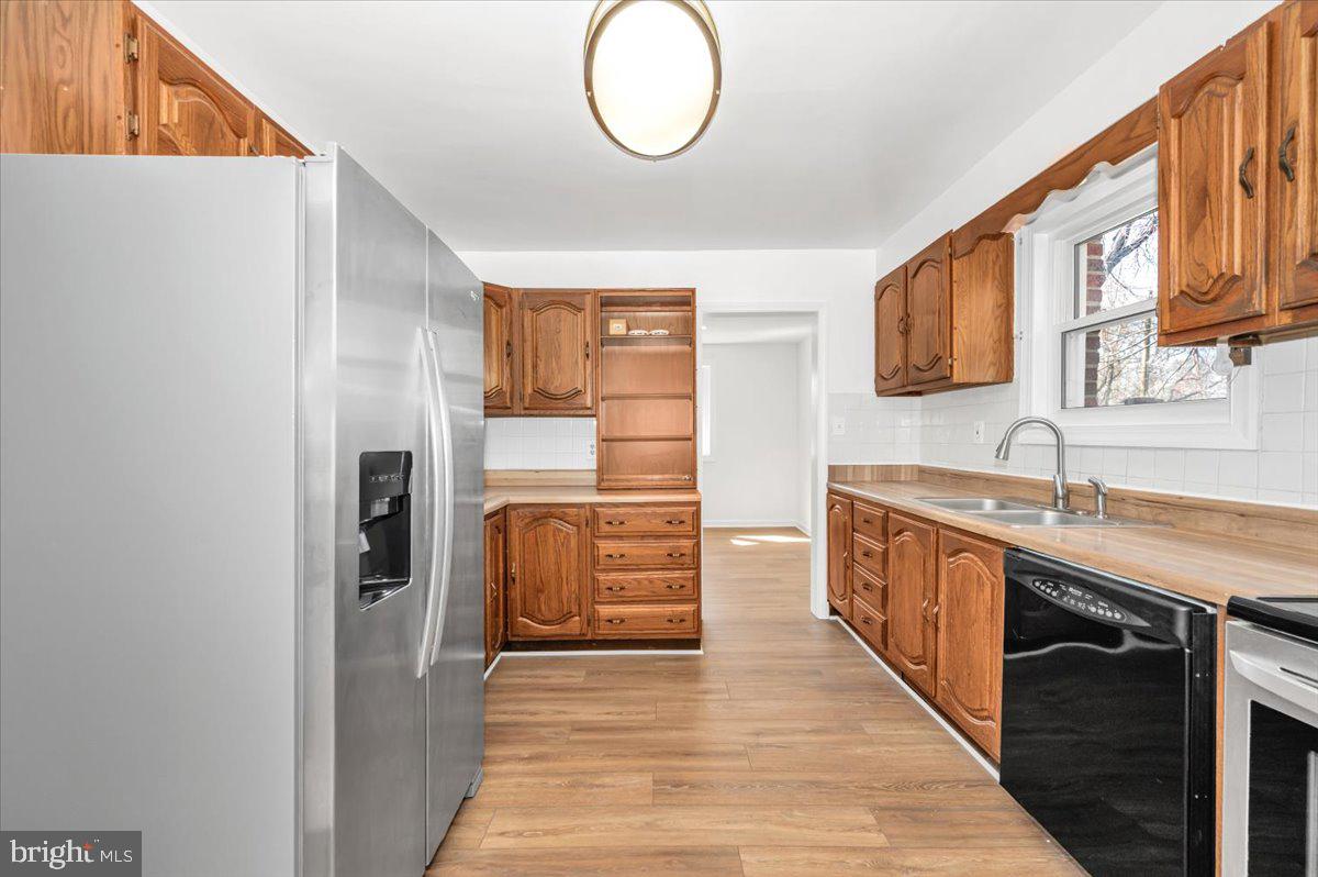11852 Huggins Drive Silver Spring, MD 20902 - Photo 13 of 63 a large kitchen with stainless steel appliances granite countertop a stove and a sink