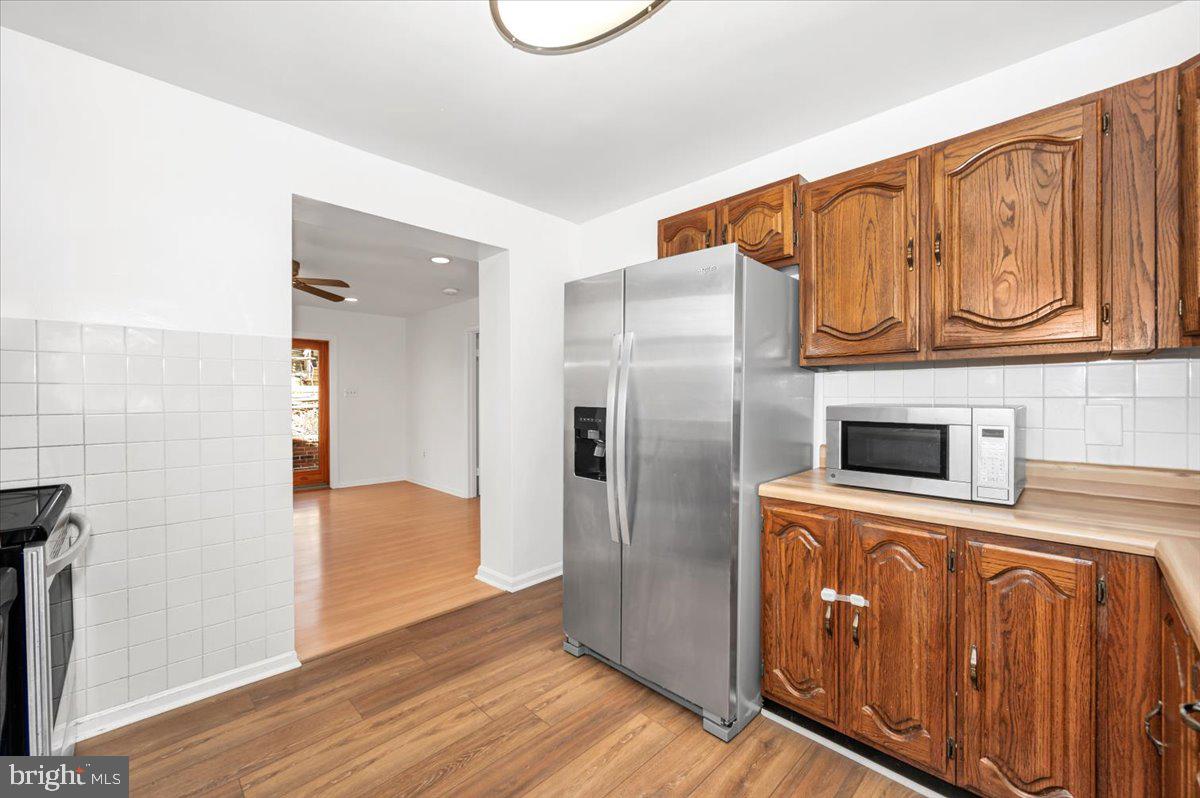 11852 Huggins Drive Silver Spring, MD 20902 - Photo 14 of 63 a kitchen with stainless steel appliances a refrigerator and a stove top oven
