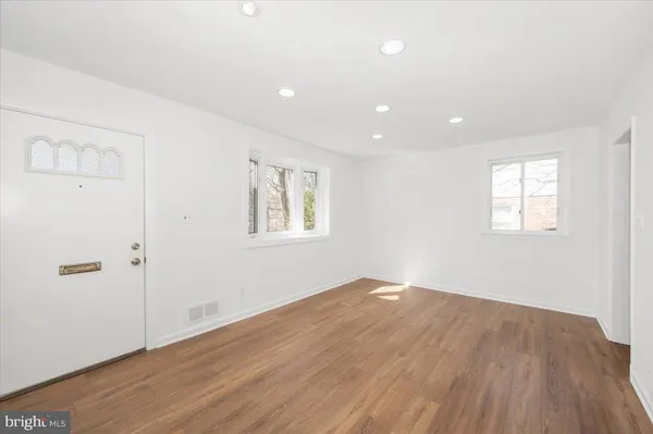 an empty room with wooden floor and window