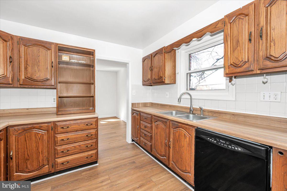 11852 Huggins Drive Silver Spring, MD 20902 - Photo 7 of 63 a kitchen with stainless steel appliances granite countertop a sink and dishwasher a stove top oven with wooden floor