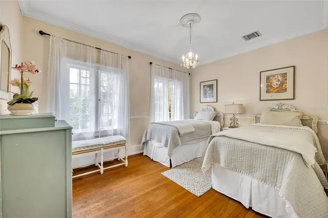 a spacious bedroom with a bed and a table chair