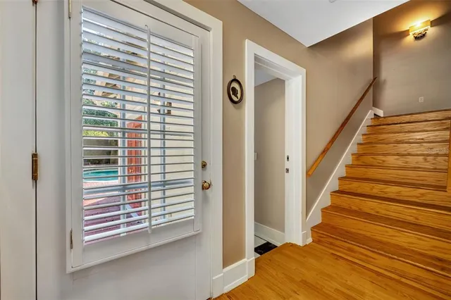a view of a hallway with wooden floor and windows