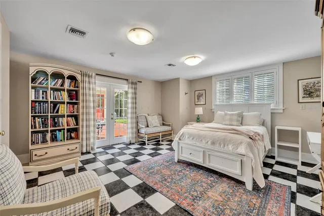 a spacious bedroom with a bed a dresser and a book shelf