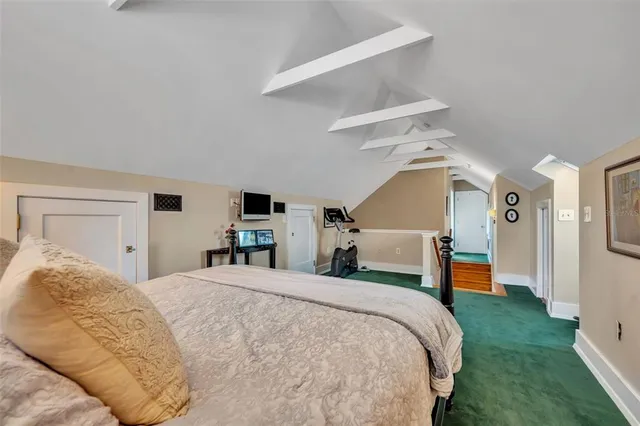 a bedroom with a large bed and a chandelier