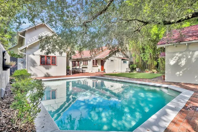 a view of a house with pool and sitting area