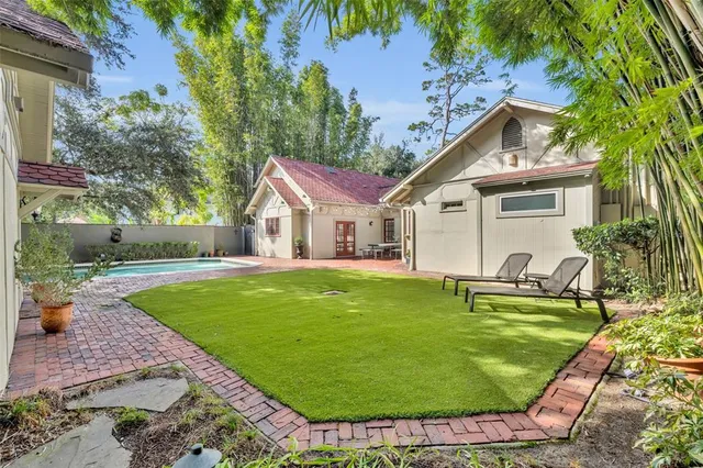 a view of a white house with a backyard and a patio
