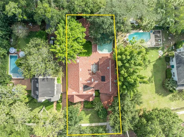 an aerial view of residential house with outdoor space and trees all around