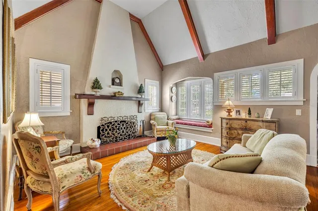a living room with furniture a fireplace and a floor to ceiling window